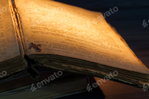Preview: Close-up golden christian cross on an old book.