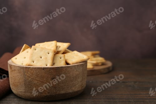 Preview: Tasty salty crackers on wooden table. Space for text