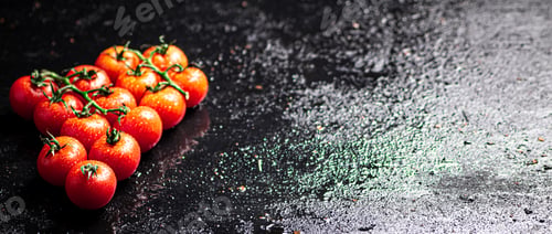 Preview: A branch of ripe tomatoes on a wet table.