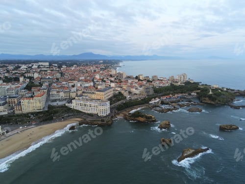 Preview: Aerial shot of a port with boats, cars, living houses with roofs with mountains under the blue sky