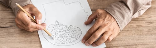 Preview: panoramic shot of retired man with alzheimer disease drawing human head and brain