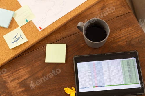 Preview: Using tablet with spreadsheet, person working at desk with coffee and notes