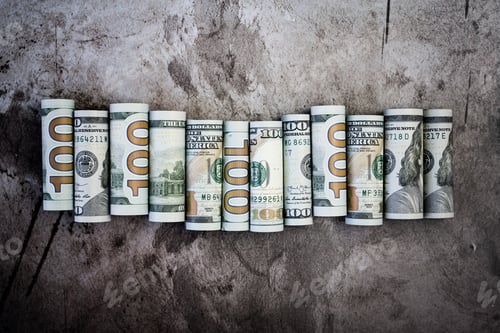 Preview: Rolled up hundred dollar bills on textured surface