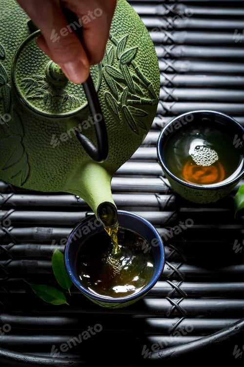 Preview: Delicious herbal tea with teapot on black table