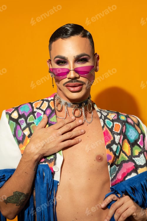 Preview: Portrait of a young drag queen in colorful dress on yellow background
