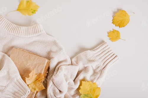 Preview: Autumn concept knitted sweater, old book and yellow leaves top view