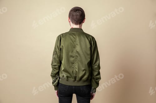 Preview: Person Wearing Green Jacket Isolated Against Tan Backdrop