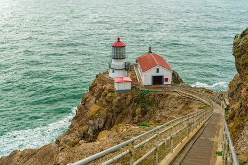 Preview: a lighthouse next to the ocean with steps leading to it