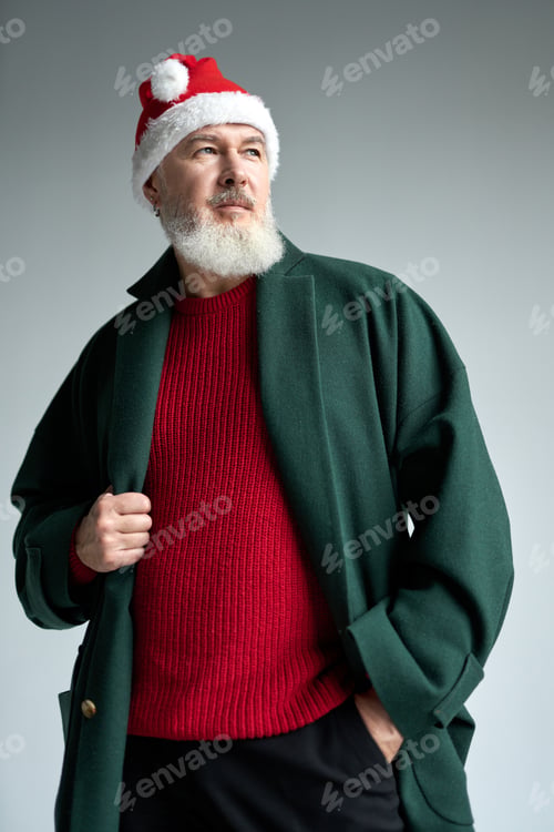 Preview: Cool middle aged man with Christmas hat wearing stylish outfit looking away, adjusting his coat