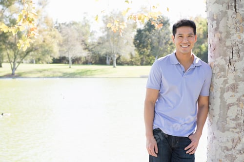 Preview: Portrait of mature man leaning against tree in park