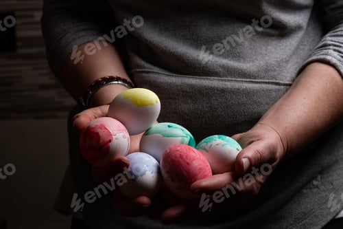 Preview: Woman holding many Easter eggs in darkness