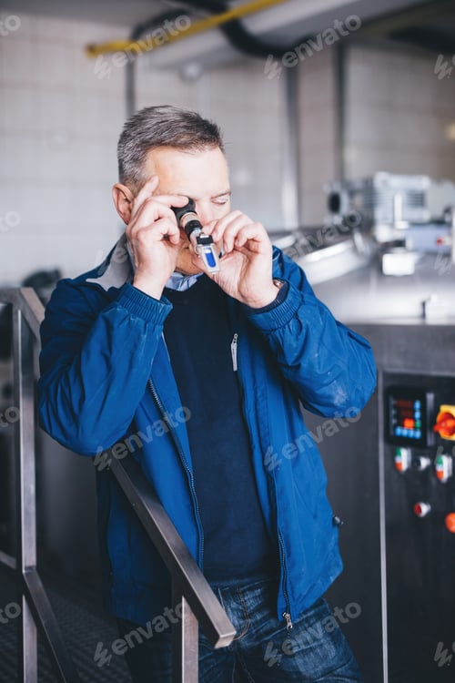 Preview: Man Inspecting Liquid with Scientific Instrument Indoors