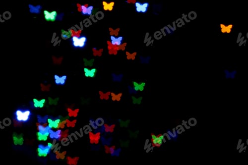 Preview: Blurred view of butterfly shaped lights on black background. Bokeh effect