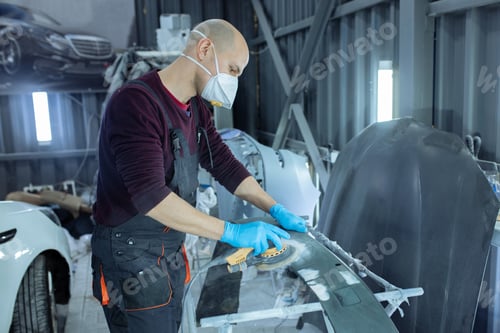 Preview: Sanding a car body part with electrical grinder machine before painting, vehicle body repair service