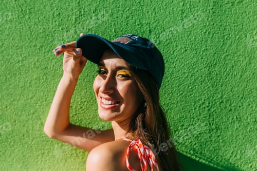 Preview: Portrait of brunette girl with long hair and cap looking at camera