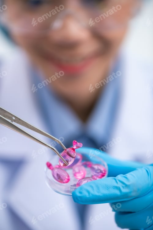 Preview: Young attractive female scientist with protective eyeglasses and mask holding