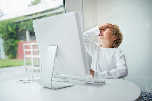 Preview: Boy at computer, hand on head