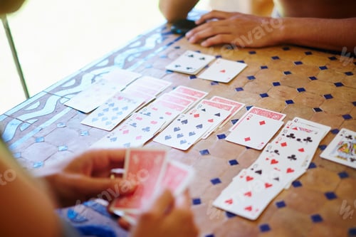 Preview: Cropped shot of mature woman and adult son playing cards at table