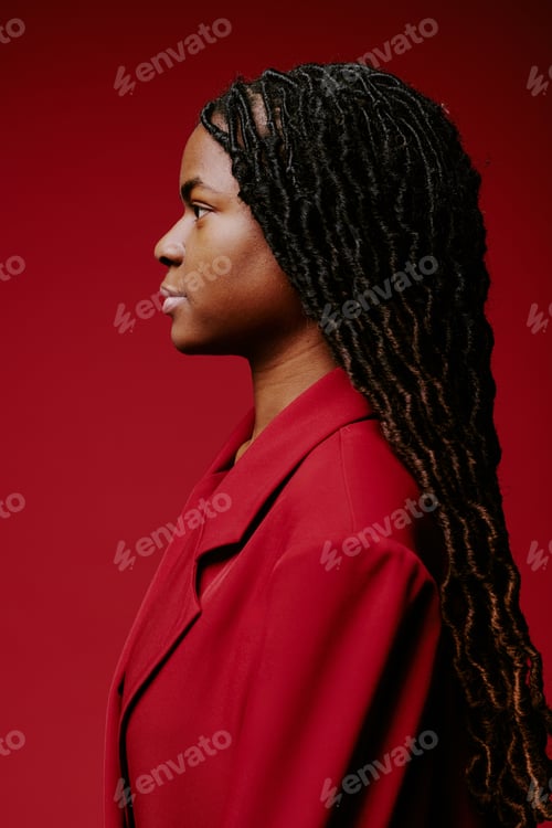 Preview: Side Profile of Woman Wearing Red Coat Against Red Background