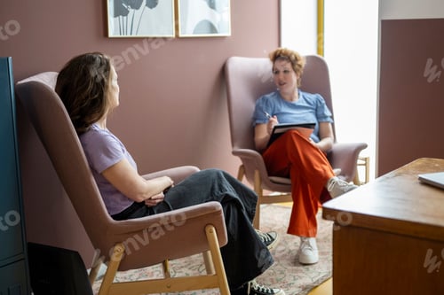 Preview: Two people engaged in conversation in a cozy room.