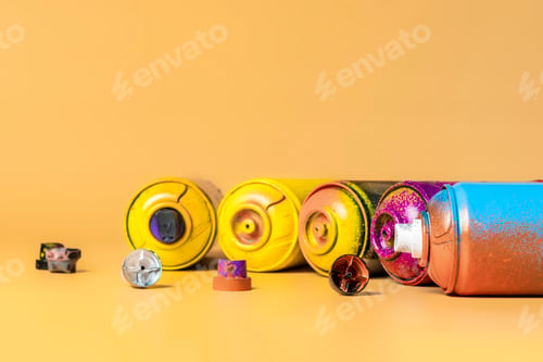 Preview: used colorful spray cans isolated on orange background b