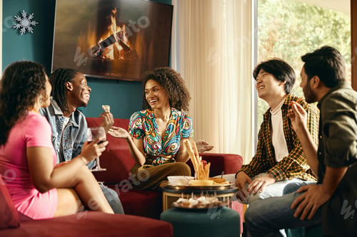 Preview: Happy friends enjoying in conversation and drinking wine during festive dinner at home party