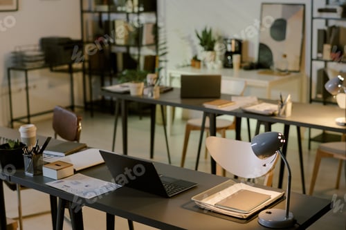 Preview: Empty Modern Office Workspace Featuring Laptops and Documents on Desks