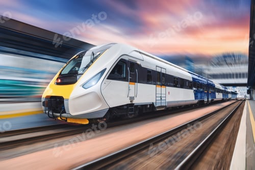 Vista previa: High speed train in motion on the railway station at sunset
