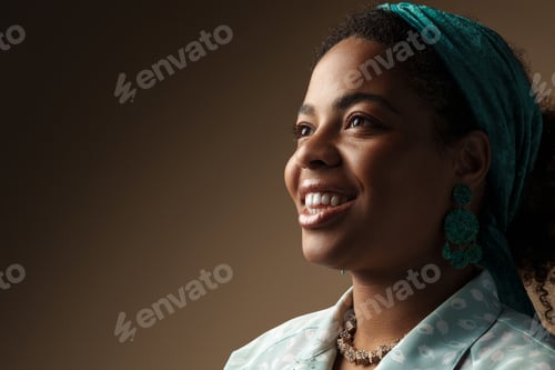 Preview: Young black woman in headband smiling and looking aside