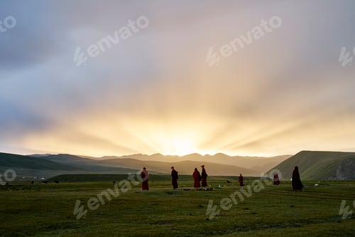 Preview: Monks walking at sunrise in a serene landscape.