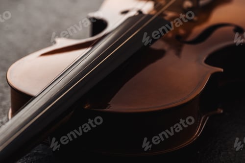 Preview: close up of strings on violoncello in darkness on grey textured background