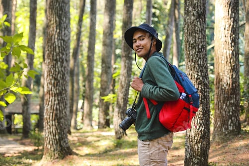 Preview: Smiling young hiker man hiking with friends at forest with dslr camera, nature photographer