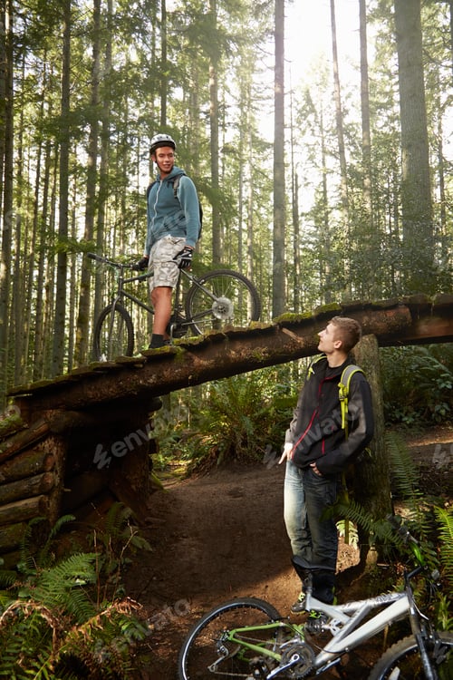 Preview: Two young men with mountain bikes, in forest
