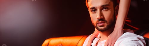 Preview: Woman touching boyfriend in shirt on black background with red lighting, banner