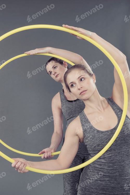 Preview: Young women practising with hula hoop, grey background