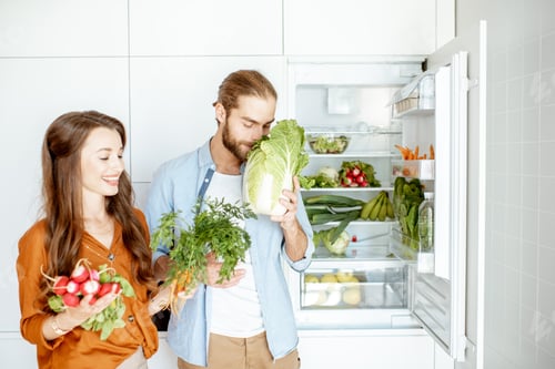 Preview: Young couple with healthy food at the kitchen