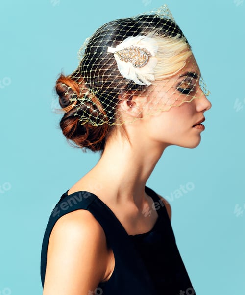 Preview: Studio shot of an elegantly dressed young woman posing against a blue background