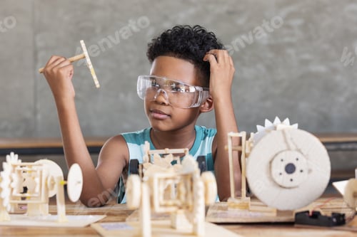 Preview: A young boy carefully aligns gears and levers