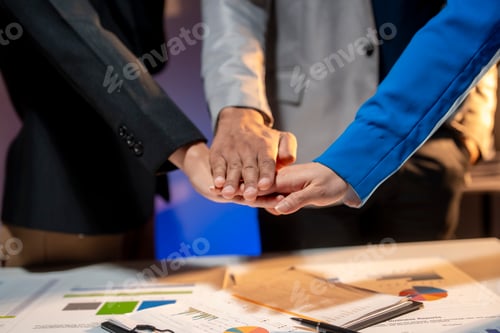 Preview: Three people are shaking hands in front of a table with papers on it