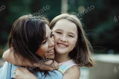 Preview: Asian mom and daughter hug, laugh and rejoice in a summer park.