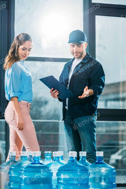 Preview: Courier with clipboard and woman looking at delivered water bottles