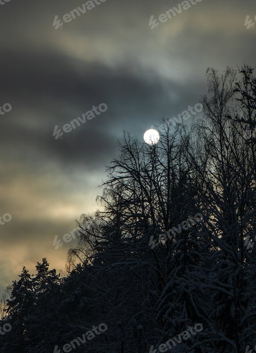 Preview: Round sun ball and dark clouds sky background on winter day