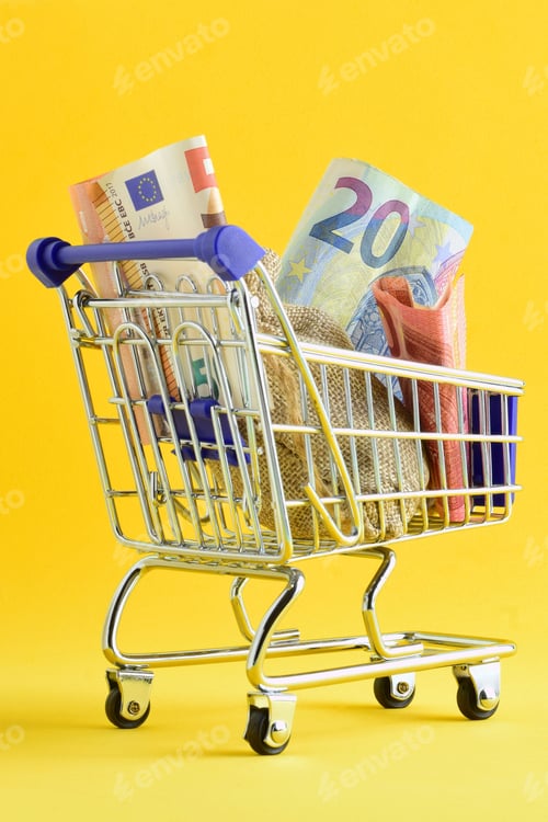 Preview: Vertical of a shopping cart with euro banknotes and a small bag with coins on yellow background