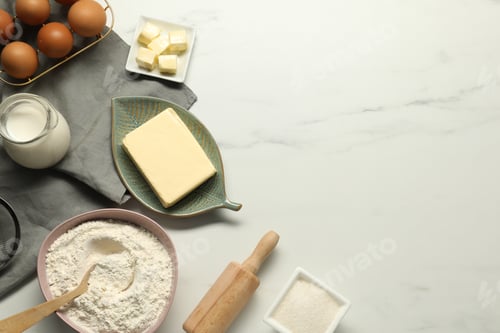 Preview: Flat lay composition with fresh butter among other products on white marble table. Space for text