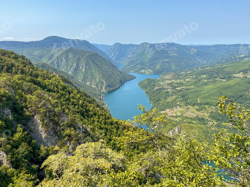 Preview: Canyon river meandering among green forested mountains; nature landscape photography
