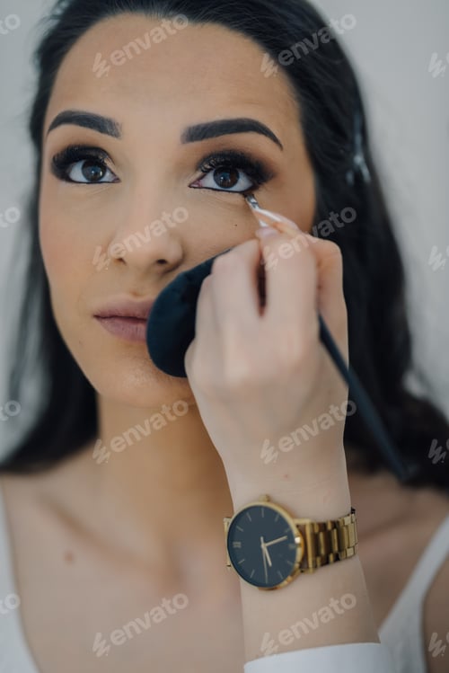 Preview: Makeup artist applying eyeliner to model's eye with brush