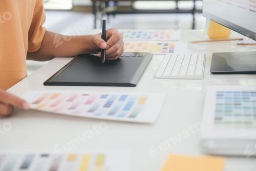 Preview: Young photographer and graphic designer at work in office.