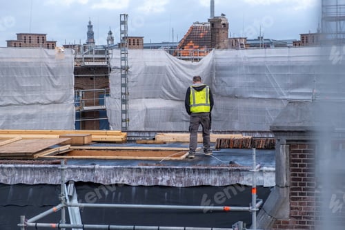 Preview: Building roof construction insulation works. Worker with yellow vest at rooftop, metal scaffolding
