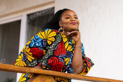 Preview: Beautiful african american woman enjoying evening on village and nature on terrace of country house
