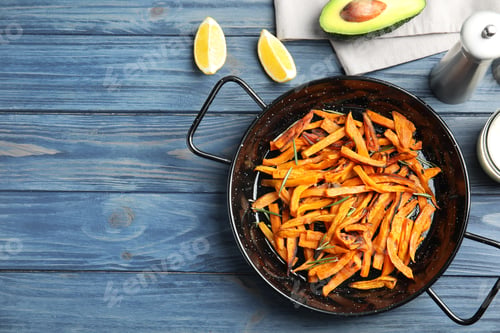 Preview: Dish with baked sweet potato slices served on wooden table, top view. Space for text